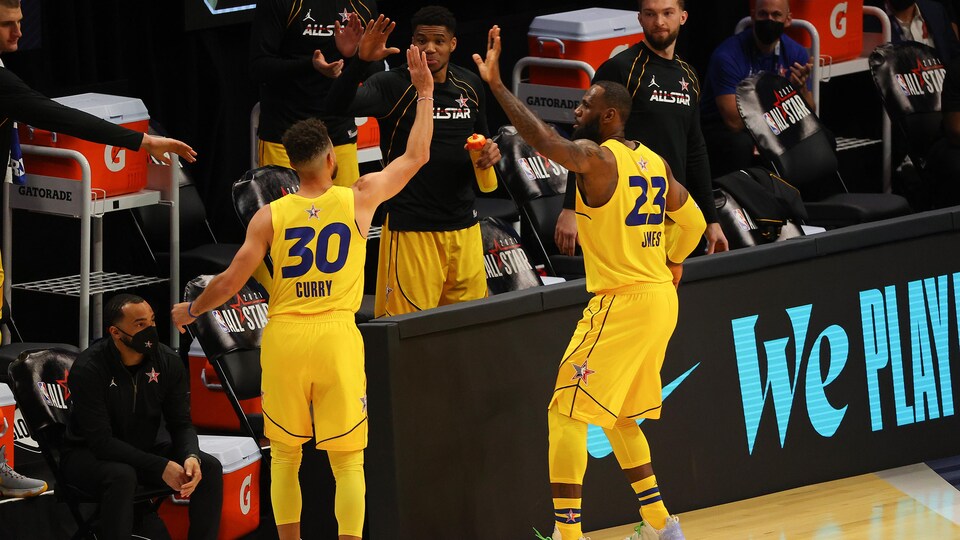 Stephen Curry et LeBron James s'apprêtent à se taper dans la main.