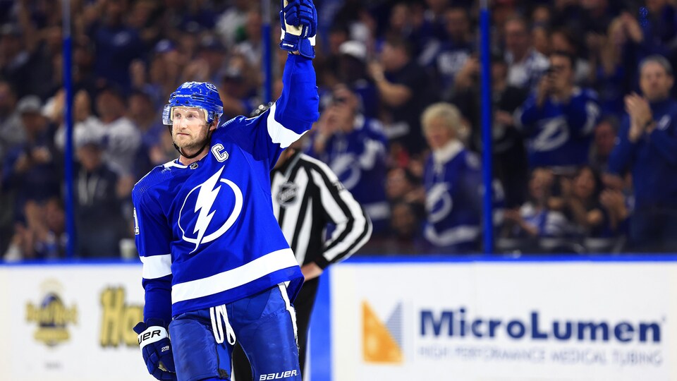 A hockey player raises his stick.