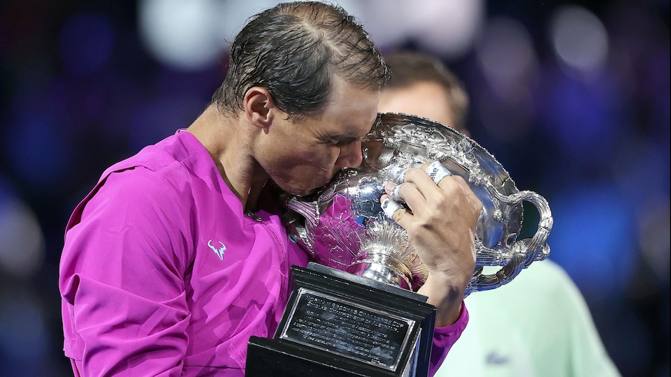 Il embrasse le trophée du vainqueur.