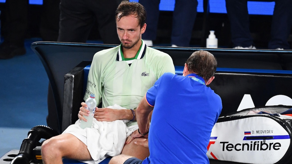 Un joueur de tennis reçoit un soin thérapeutique.