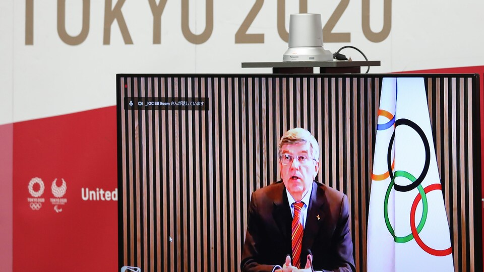 Il apparaît à l'écran d'un moniteur superposé au logo Tokyo 2020.