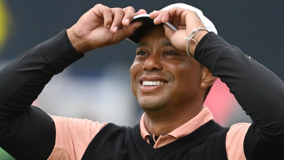 One golfer smiled and returned his cap to his head with both hands. 
