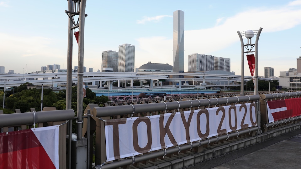 Une bannière Tokyo 2020 est installée sur une balustrade.