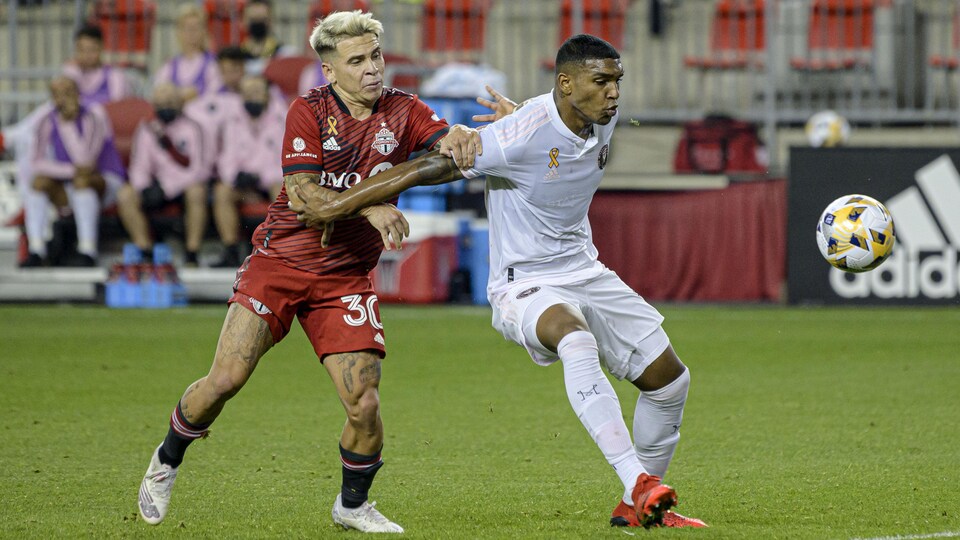 Deux joueurs de soccer se disputent le ballon.