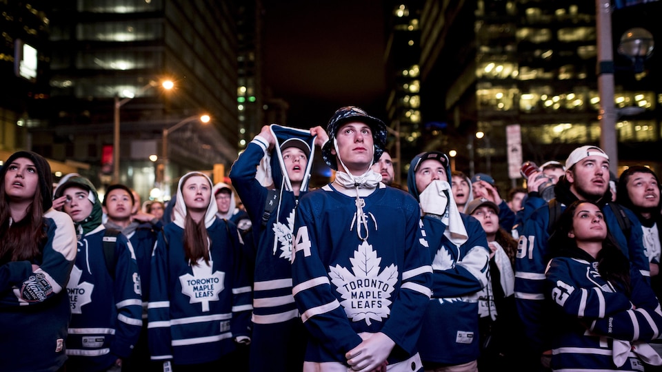 Une foule de partisans des Maple Leafs regardent l'écran géant à l'extérieur de l'aréna Banque Scotia, à Toronto.