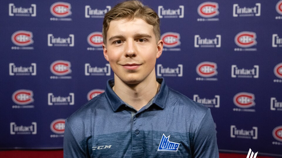 He smiled in front of the Canadiens logos.