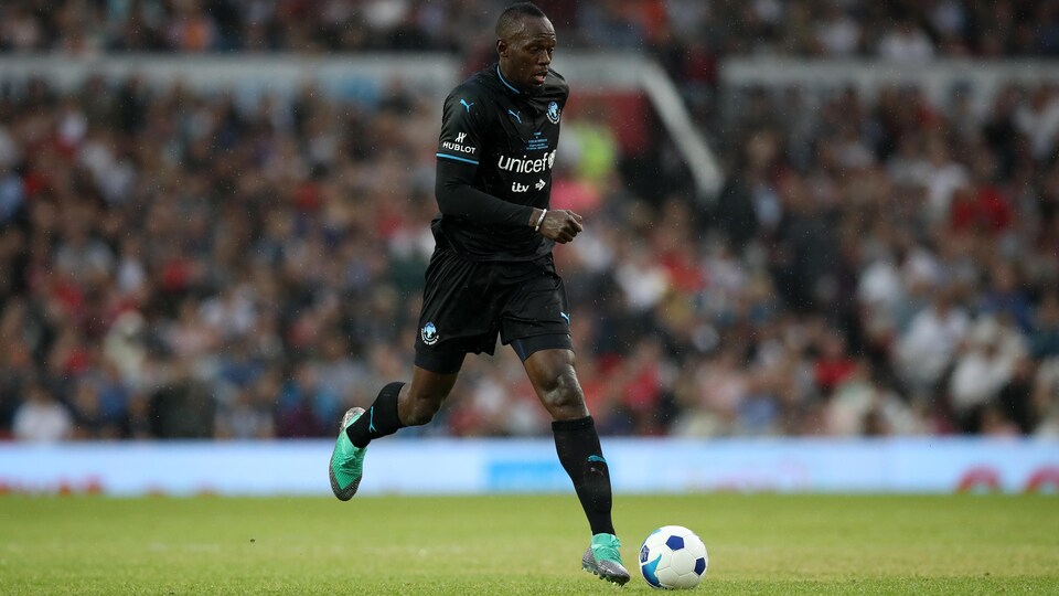 Usain Bolt dribble le ballon.