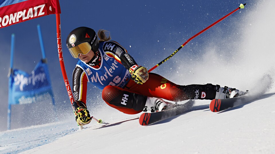 Une skieuse passe une porte dans une épreuve de vitesse.  