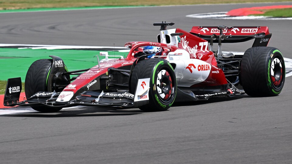 Un pilote de F1 tourne à droite dans sa monoplace sur un circuit.