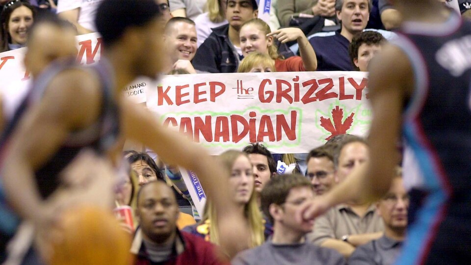 Des partisans montrent une affichant indiquant que les Grizzlies, l'emblème de leur équipe, sont Canadiens et devraient le rester.