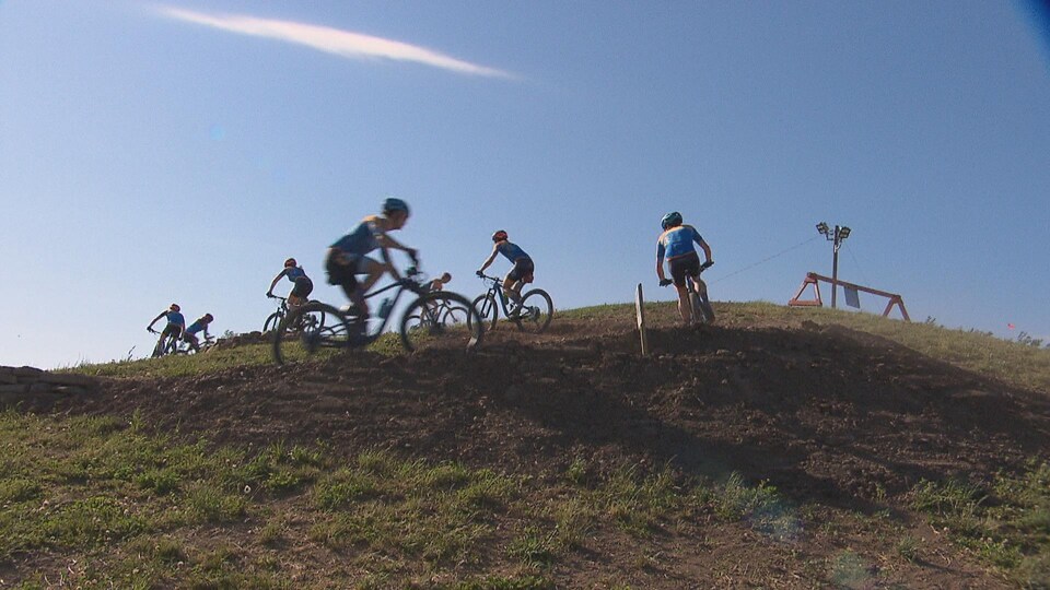 Des vélos se suivent sur une butte.