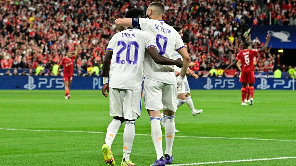 Two soccer players hug after a goal.