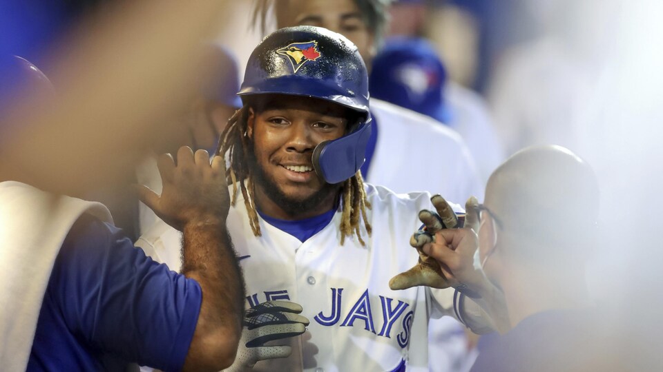 Vladimir Guerrero fils est félicité par ses coéquipiers après avoir frappé un coup de circuit.