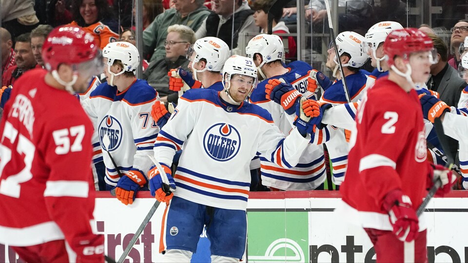 Le hockeyeur Warren Foegele patine devant le banc où se trouvent ses coéquipiers.