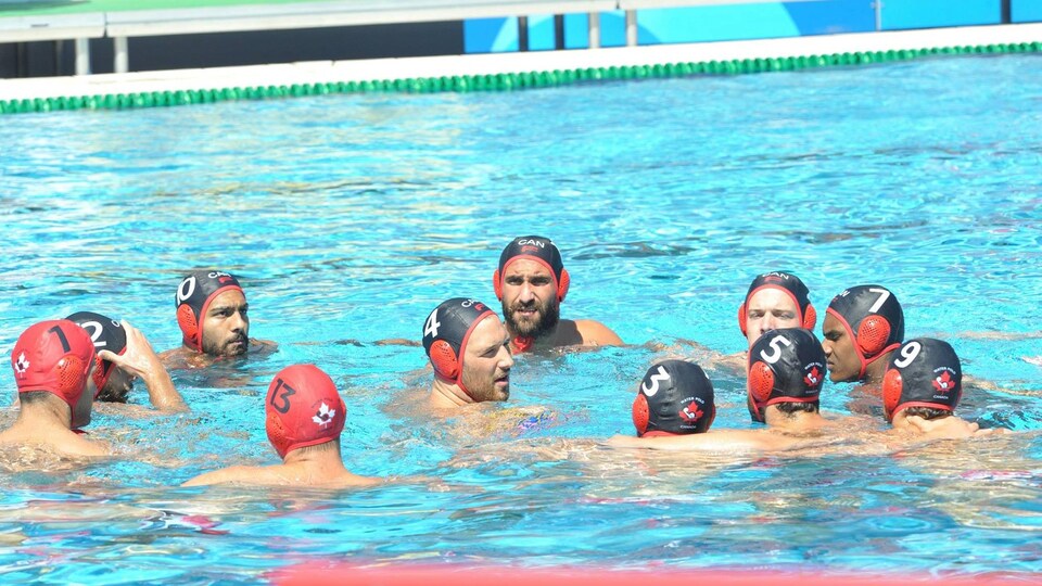 Les joueurs sont réunis autour de leur capitaine dans la piscine.
