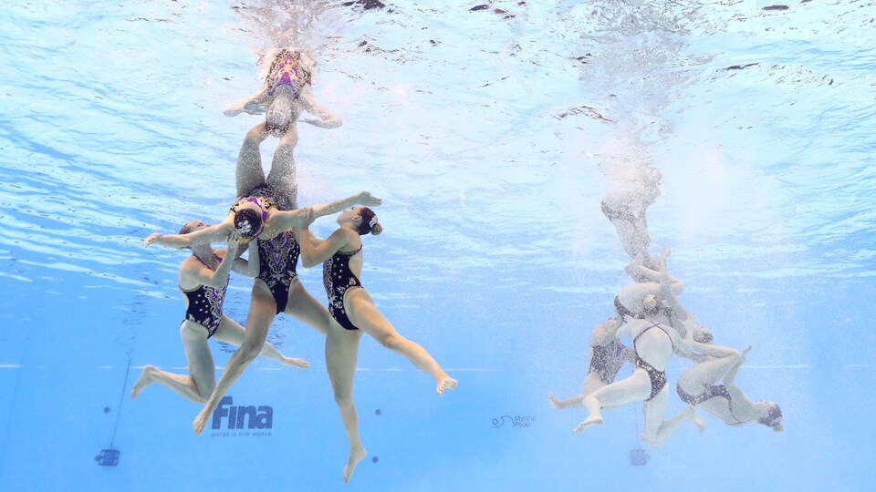 Des nageuses exécutent une performance dans l'eau.