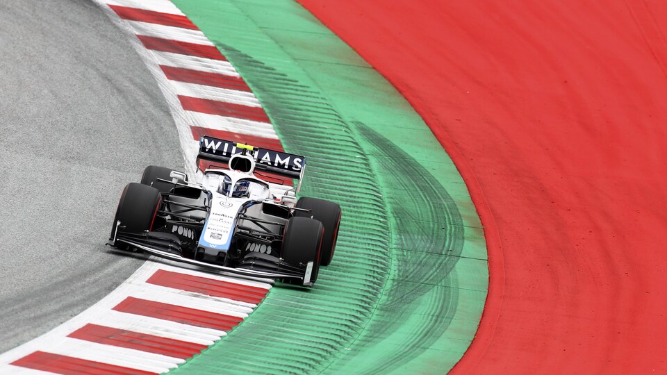 Une monoplace de Formule 1 dans un virage à pleine vitesse.