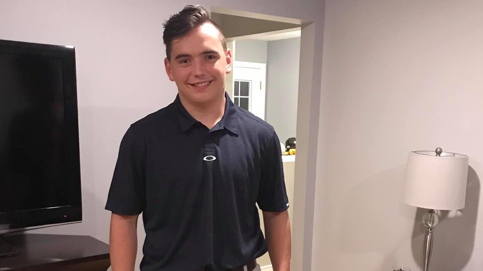 Jeune homme souriant en polo.