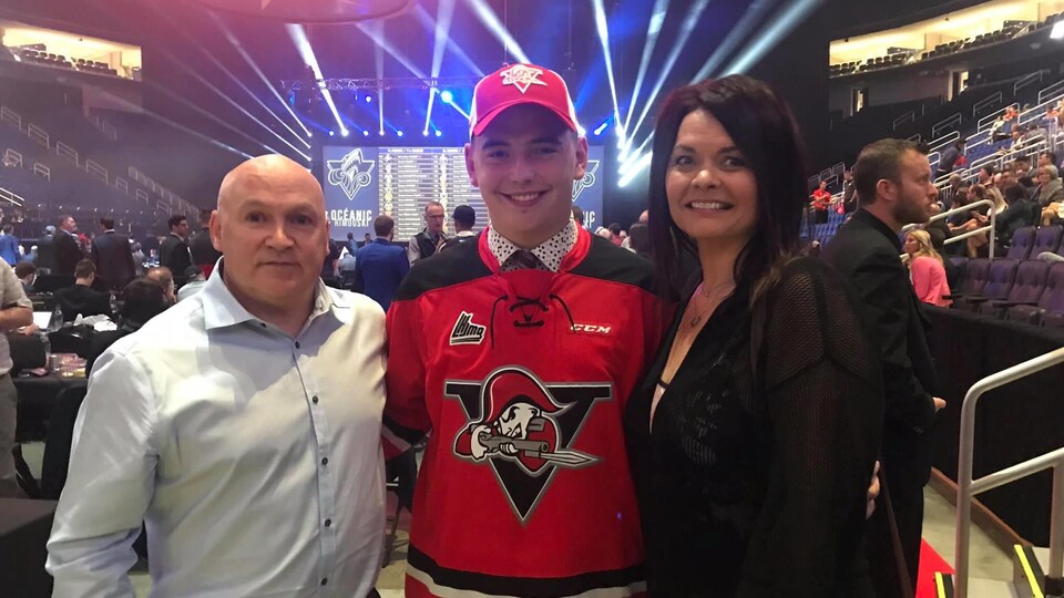La famille Duplessis sourit. Yanic est au centre avec son chandail rouge avec le logo des Voltigeurs