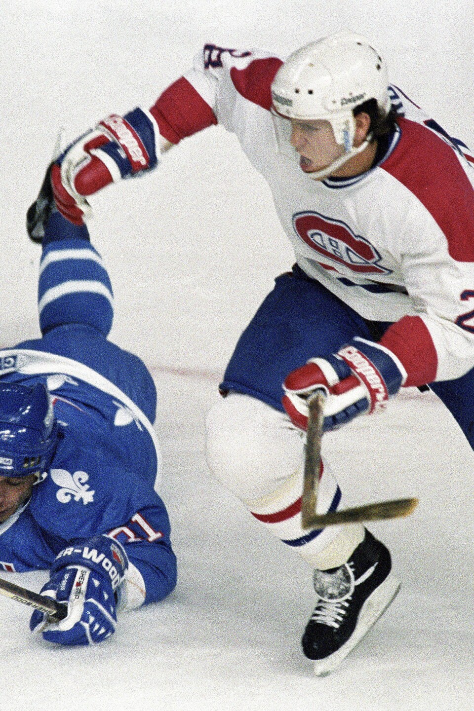 Valeri Kamensky, des Nordiques de Québec, tombe sur la glace en tentant de bloquer Éric Desjardins, du Canadien de Montréal.