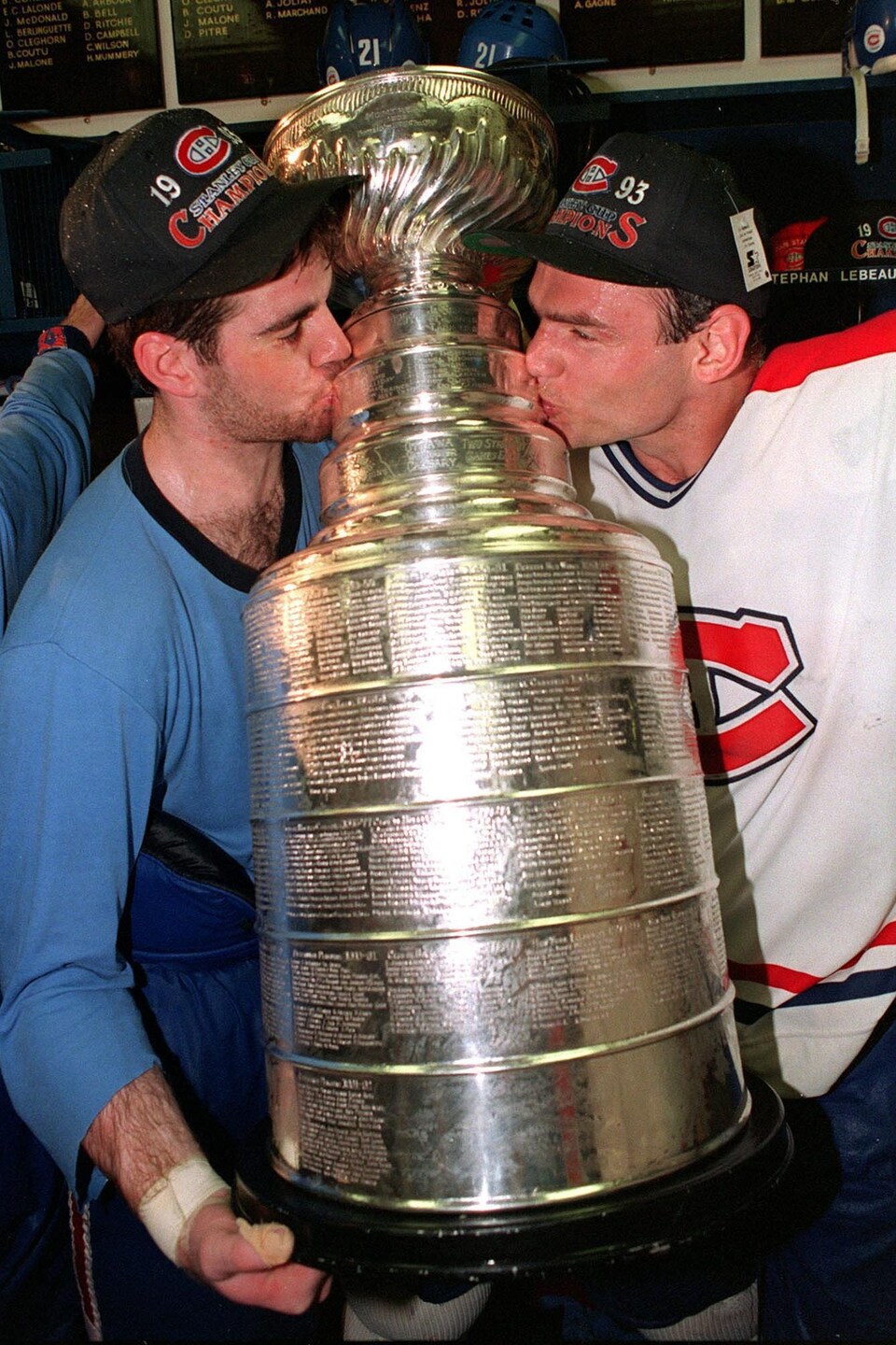 Deux joueurs de hockey embrassent le trophée.