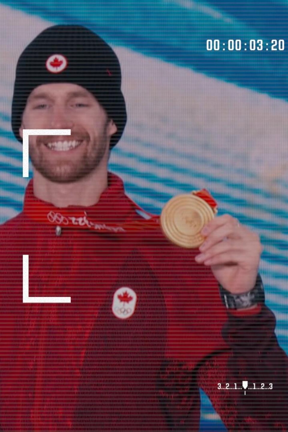 Un athlète sourit en brandissant sa médaille d'or.