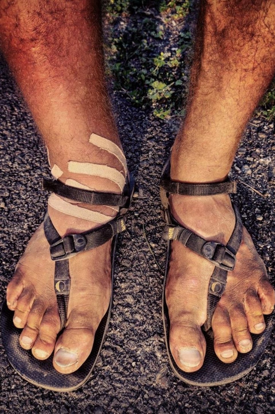 Gros plan des pieds couverts de bandages d'un homme en sandales