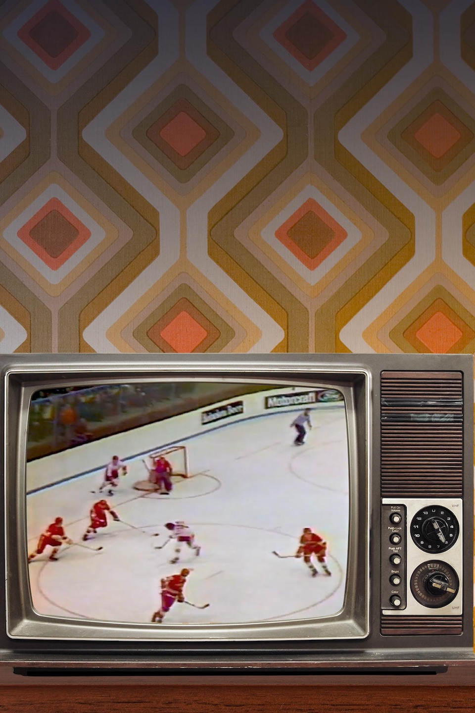 Des images d'un match de hockey dans une télé d'époque, laquelle se trouve dans une pièce avec tapisserie des années 1970