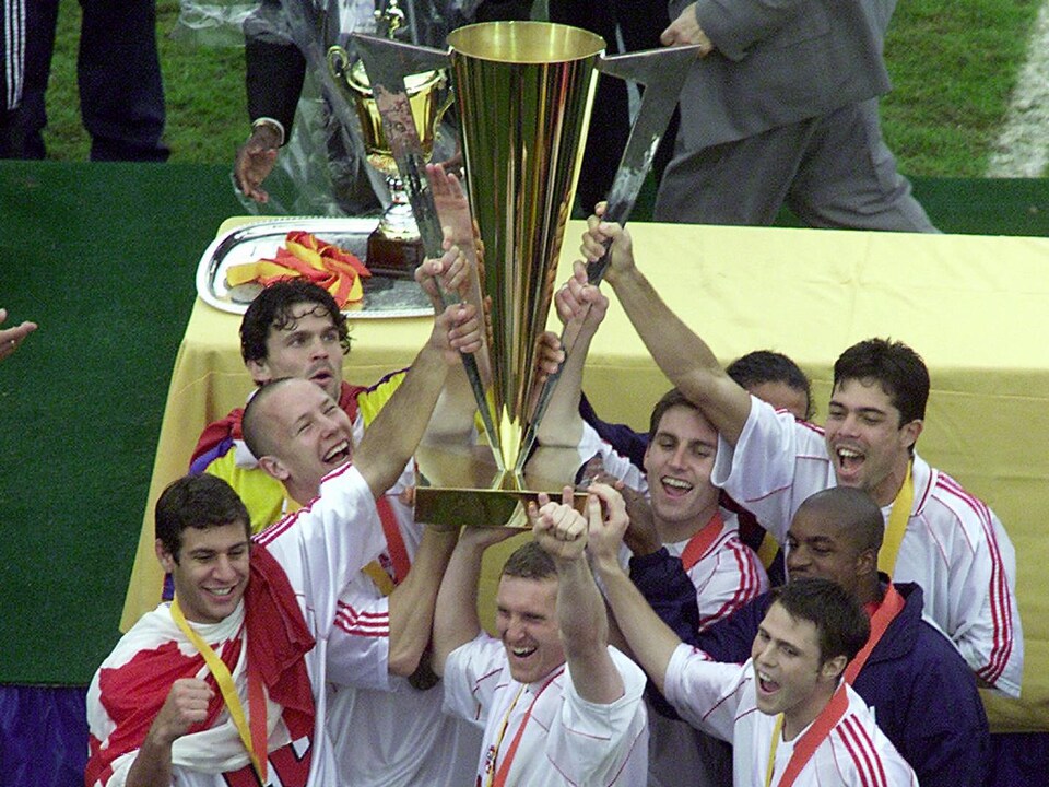 L'équipe tient le trophée à bout de bras.