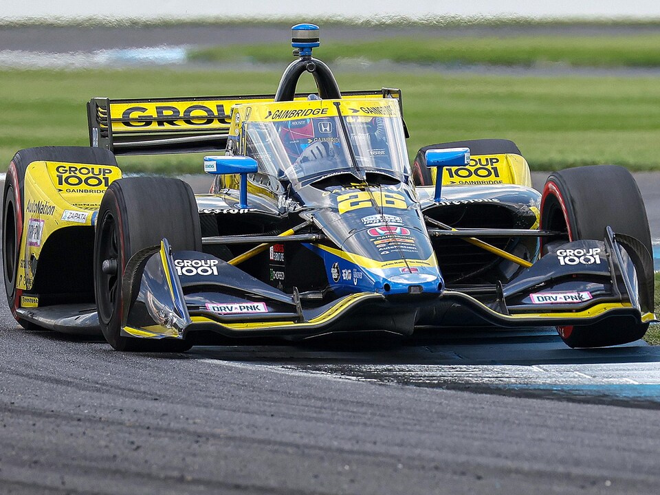 Une voiture de la série IndyCar roule sur un circuit.