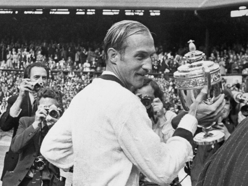 An athlete turned his head and presented the trophy to his winner at the Wimbledon Championship.