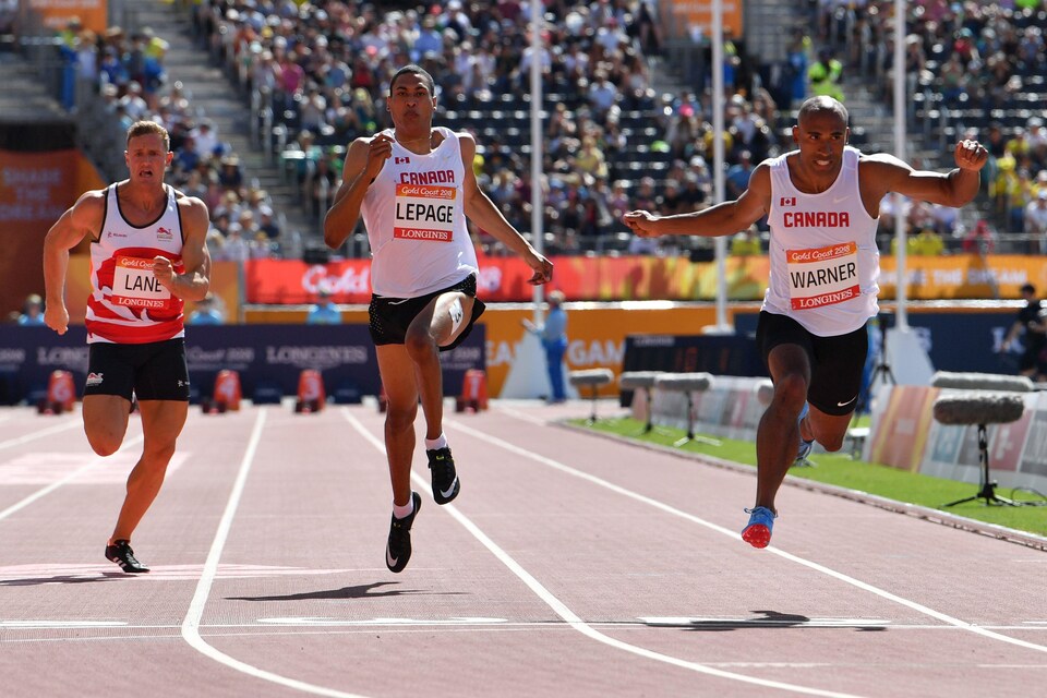 Damian Warner, à droite, plonge pour devancer Pierce Lepage et John Lane au 100 m du décathlon des Jeux du Commonwealth à Gold Coast.