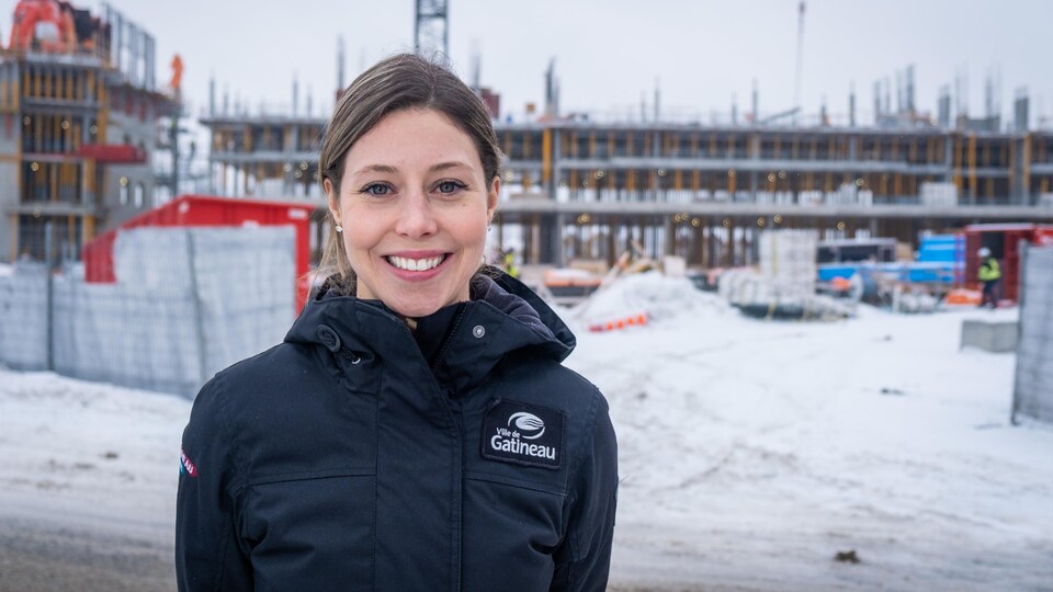 Portrait de la femme devant un projet immobilier en construction.