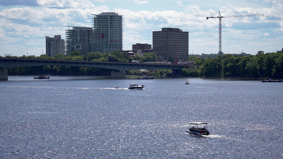 Des bateaux naviguent sur la rivière des Outaouais, avec en fond, des immeubles.