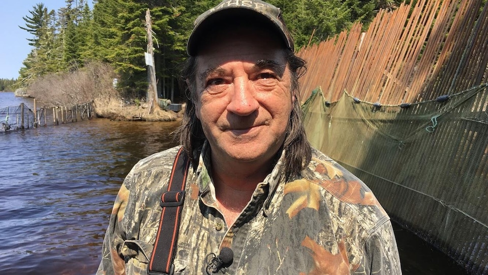 Brian Richard dans le lac à côté d'un barrage en bois.