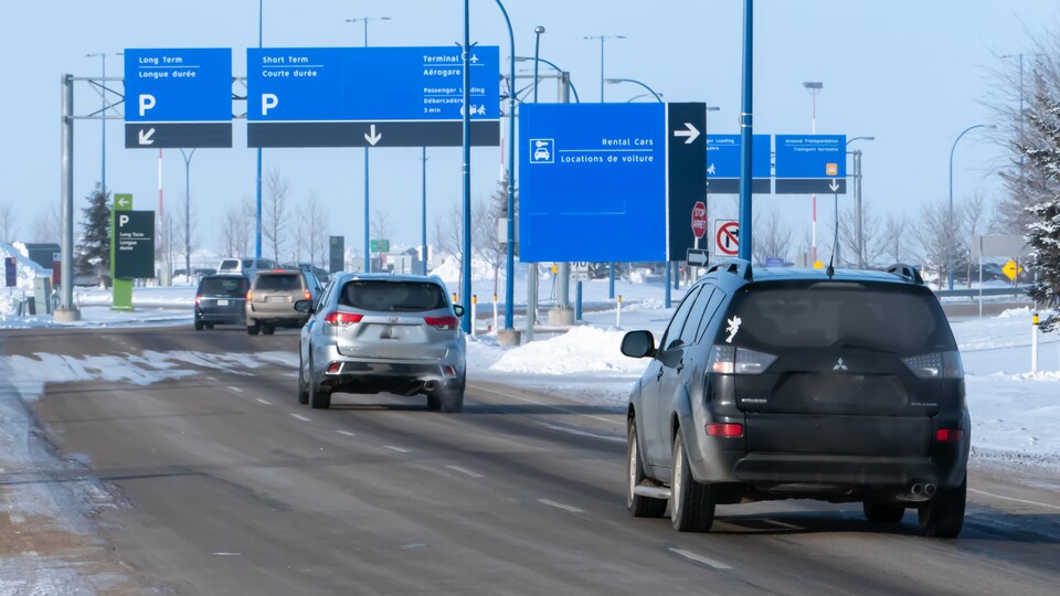 Des automobiles roulent en direction de l'aéroport international de Regina.