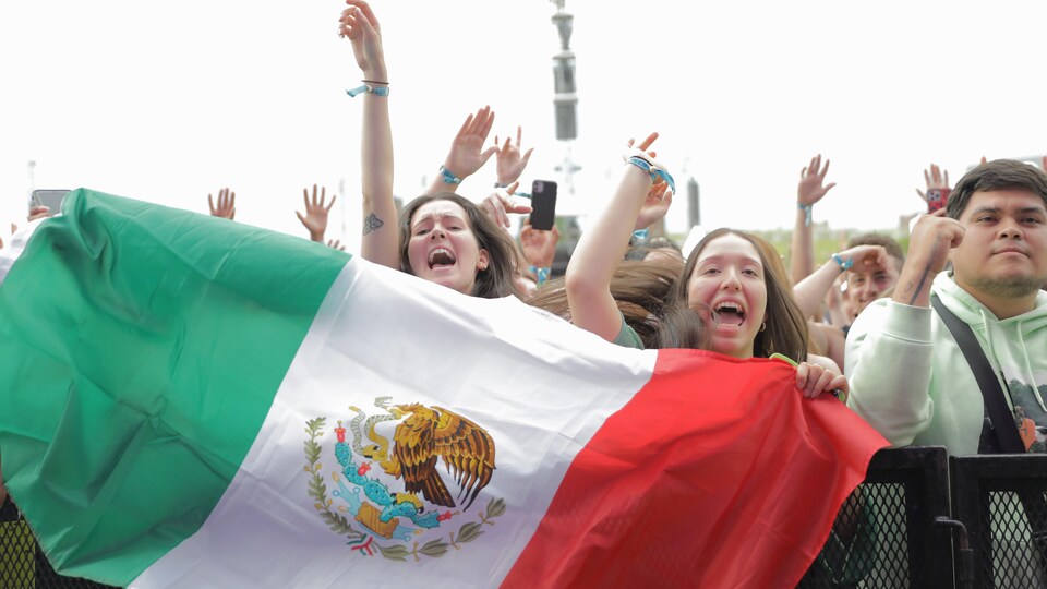 Des festivaliers montrent le drapeau mexicain.