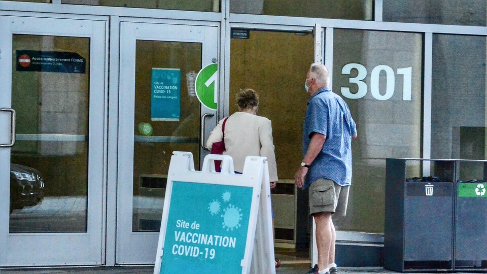 Deux personnes entrant dans un site de vaccination COVID-19.