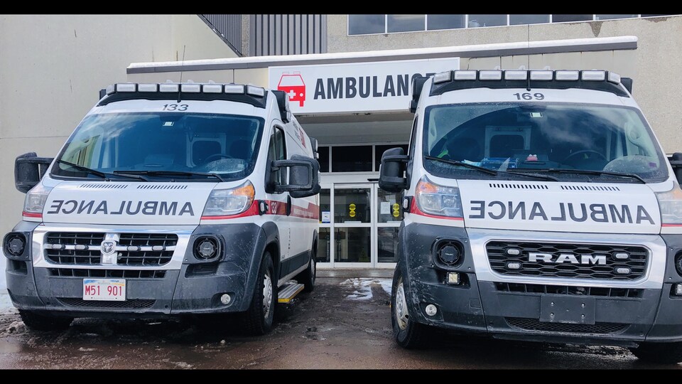 Des ambulances devant une entrée d'hôpital.