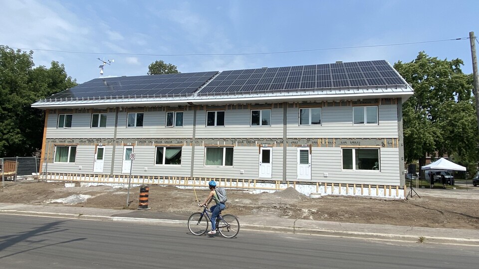 Un immeuble en travaux avec un cycliste devant.