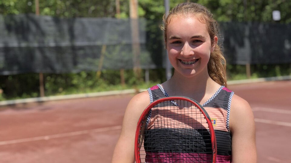 Ariane Souligny pose pour une photo avec sa raquette de tennis.