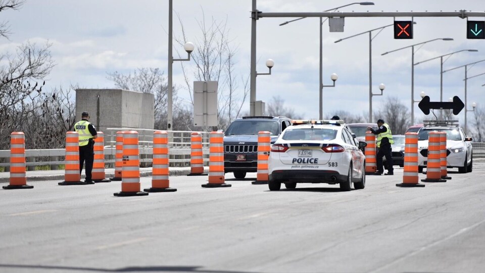 Des agents de police interceptent les automobilistes à un poste de contrôle.