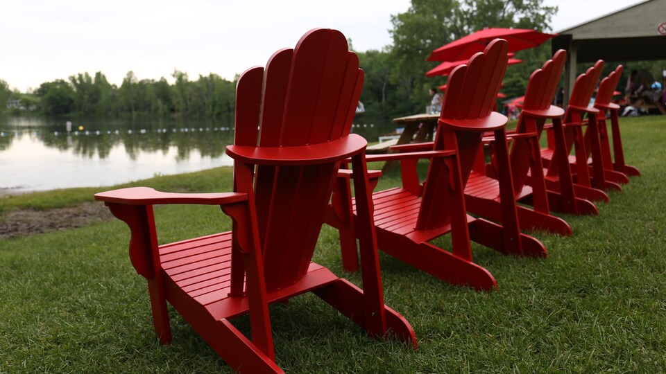 Des chaises rouges devant un lac