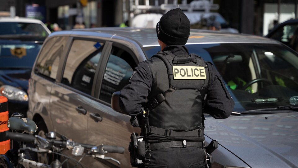 Un policier devant une file de voitures. 