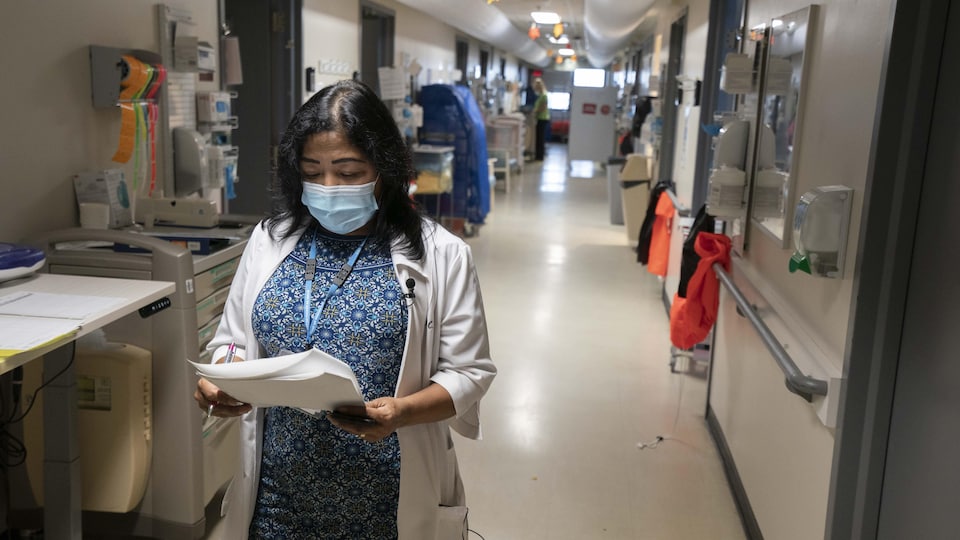 Une infirmière est dans un corridor d'hôpital.