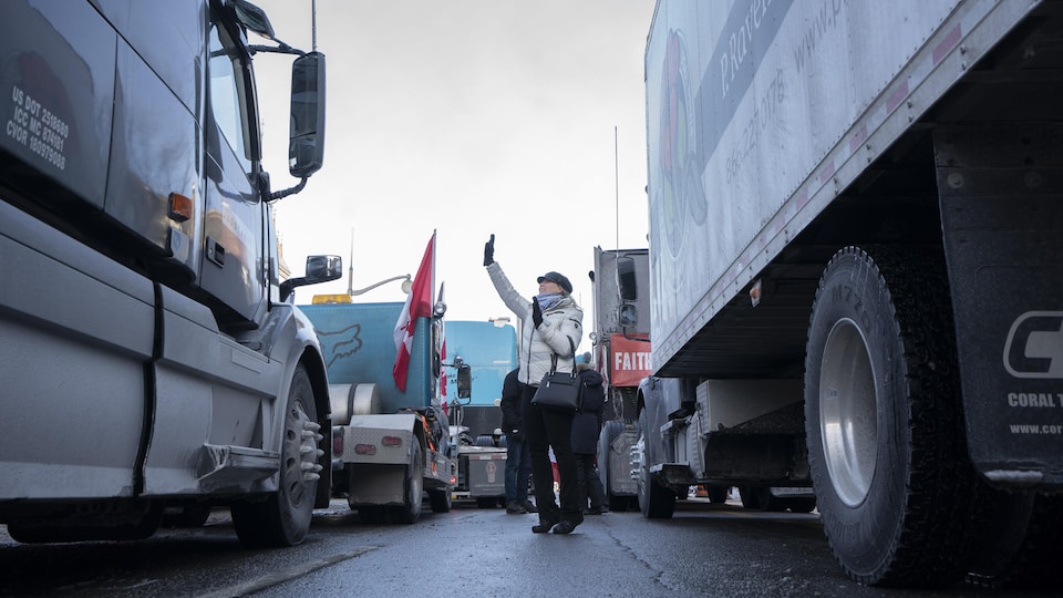 Une manifestante entre des camions.