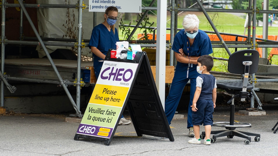 Une infirmière s'adresse à un enfant.