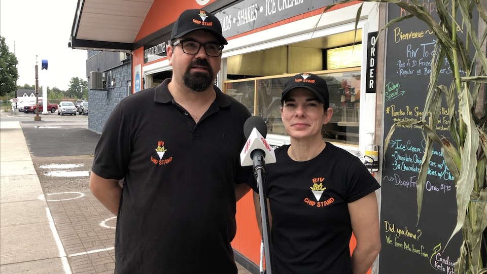 Bruno et Kate Lepage devant leur commerce orange.
