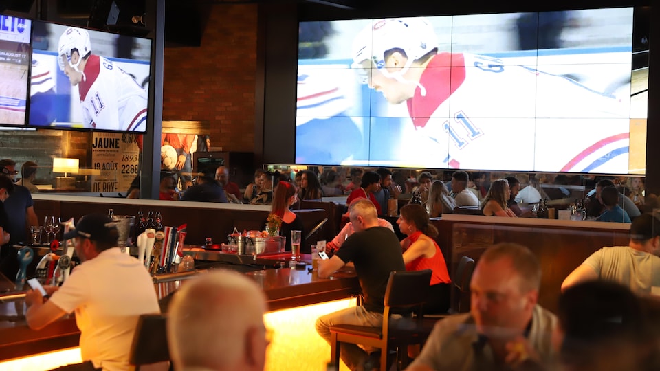 Un restaurant diffuse un match des Canadiens de Montréal sur écran géant.