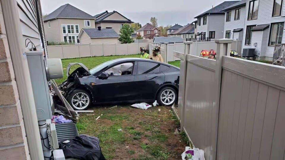 Une voiture accidentée près d'une résidence.